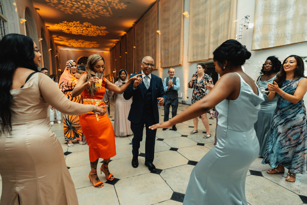 Guests dancing at Sudanese wedding reception in Kew Gardens London with cultural music and traditions