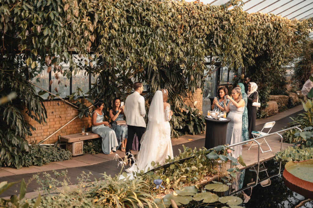 Wedding guests enjoying cocktails inside the Princess of Wales Conservatory at Kew Gardens