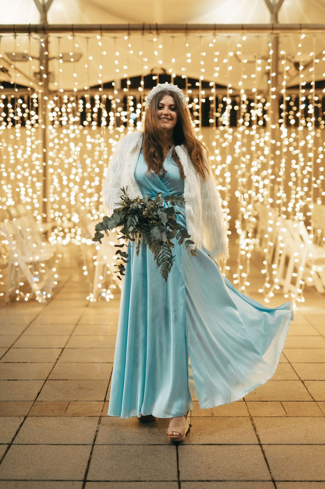 Bride stood in blue dress holding a bouquet
