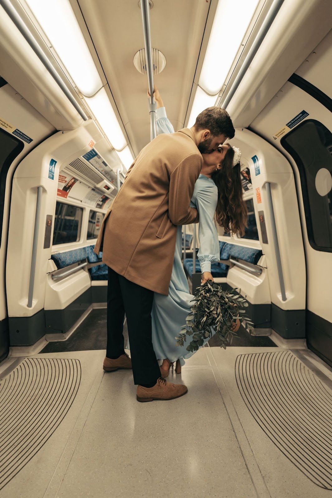 Bride and groom kissing on a London Underground train