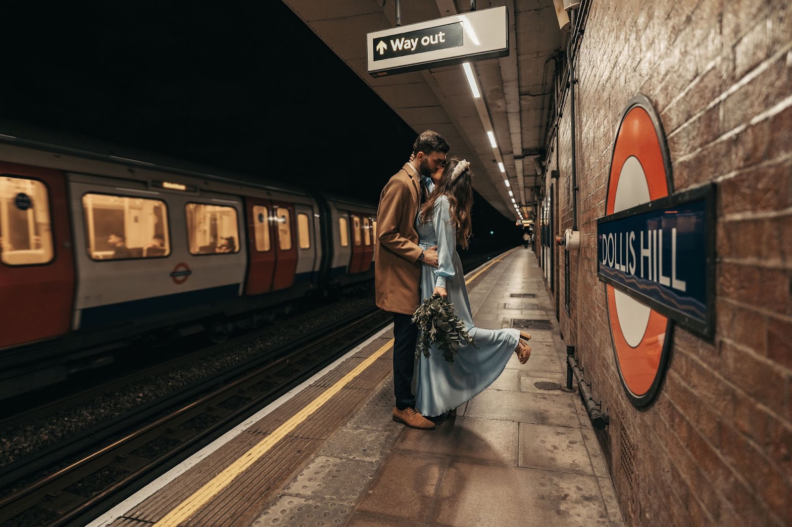 Bride and groom kiss on London Underground platform