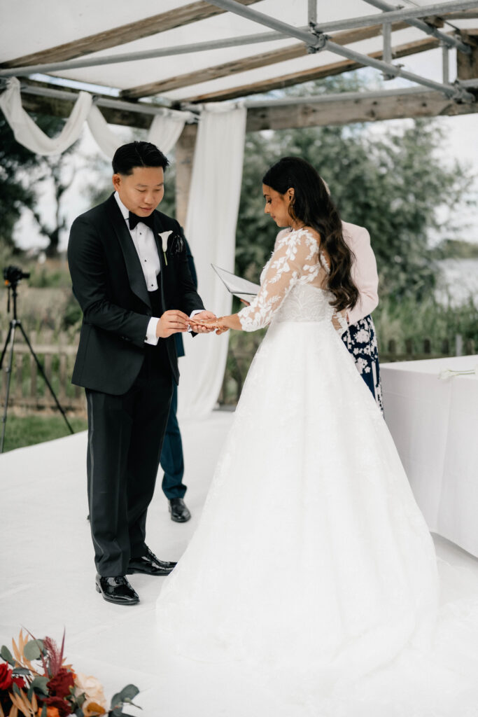 Bride and groom exchanging vows during a luxury waterfront wedding
