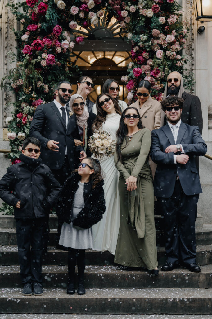 Stylish wedding guests wearing sunglasses outside Chelsea Town Hall
