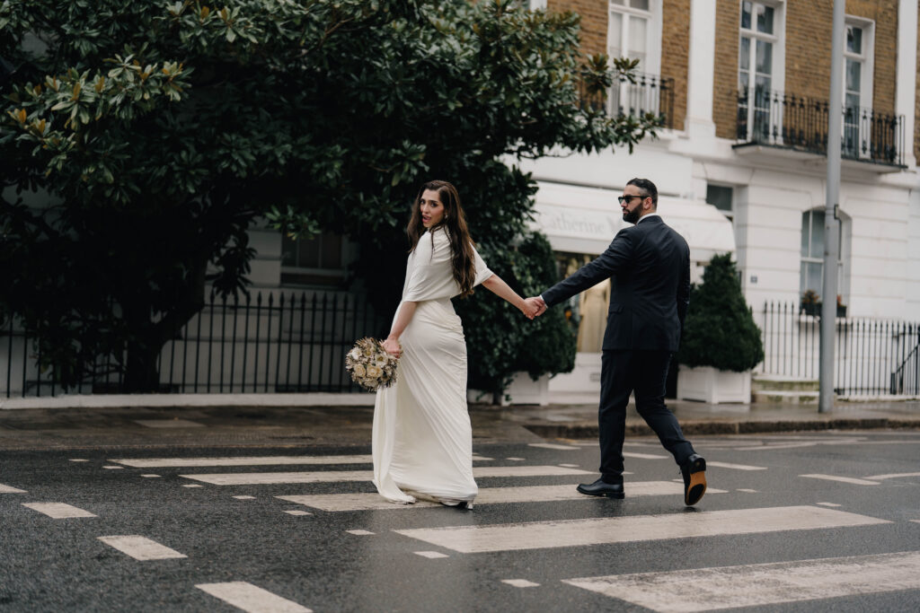 Bride and groom walking through snowy Chelsea streets