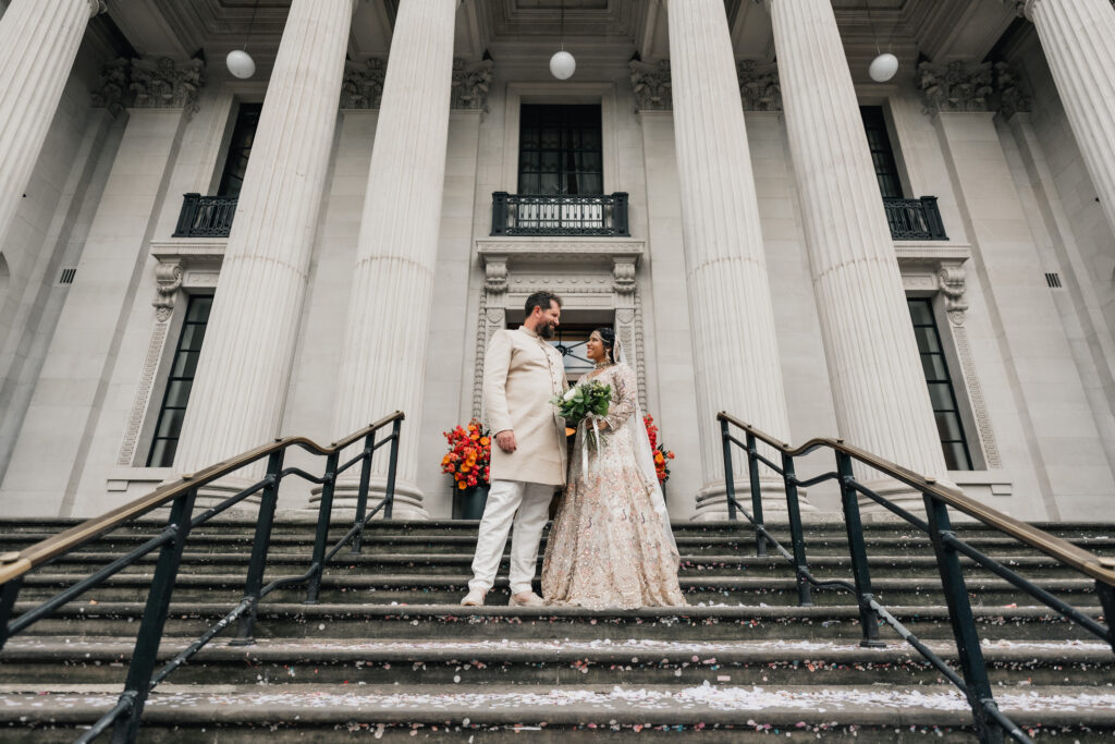 Bride and groom standing outside Marylebone Town Hall